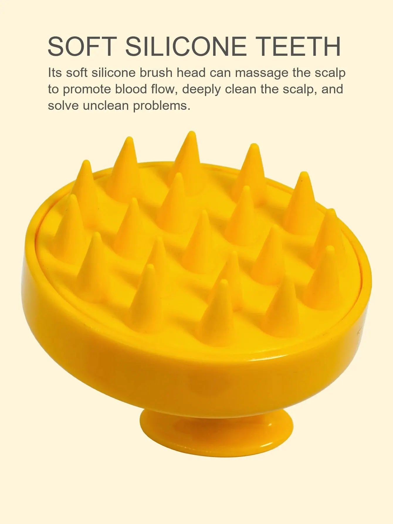 Yellow scalp massage brush with soft silicone teeth on a beige background